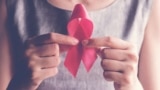 woman holding pink ribbon, breast cancer awareness, October pink concept