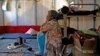 FILE - Syrian refugee Walaa, 26, sits inside her family's tent at the Souda municipality-run camp on the island of Chios, Greece, Sept. 7, 2016. 